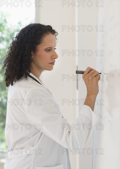 Doctor writing on whiteboard.