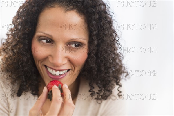 Portrait of woman eating strawberries.