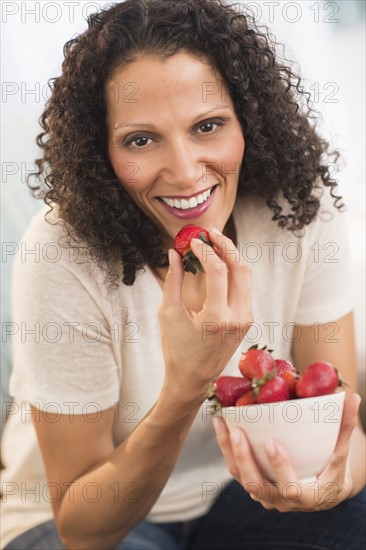 Portrait of woman eating strawberries.