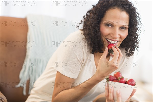 Portrait of woman eating strawberries.