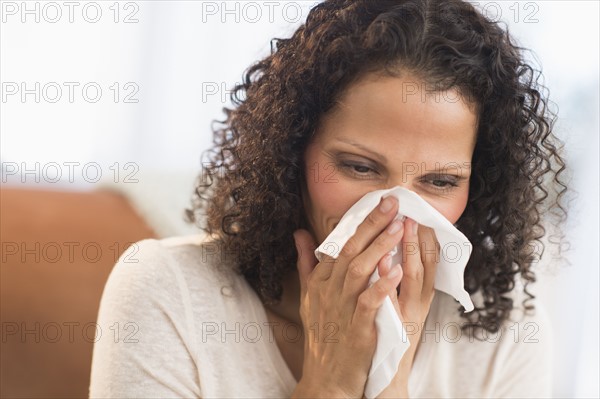 Portrait of woman blowing nose.