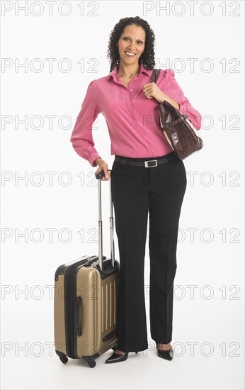 Studio shot of woman walking with suitcase.