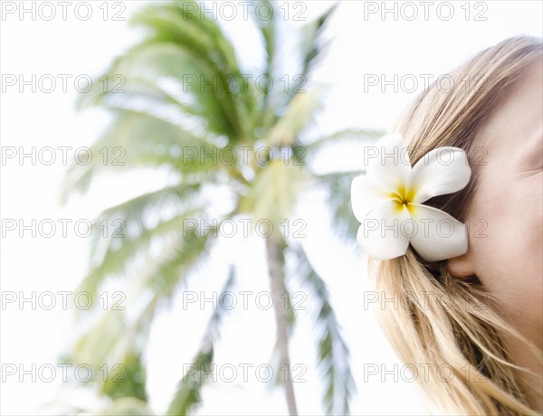 Woman wearing plumeria flower in hair. Photo : Jamie Grill