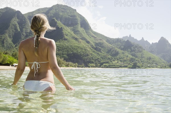 Tunnels Beach, Woman walking in sea. Photo : Jamie Grill