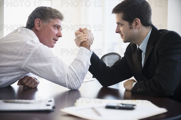 Office workers wrestling on desk. Photo : Jamie Grill