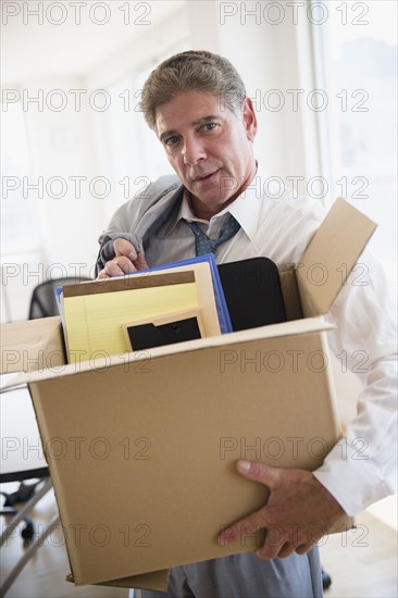 Office worker with packed carton box. Photo : Jamie Grill