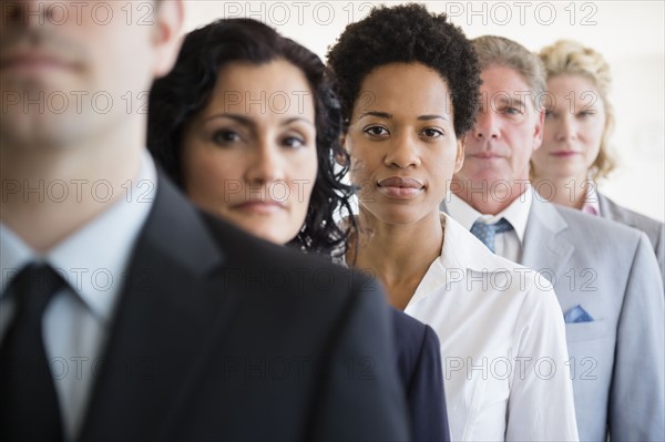 Portrait of office workers standing in row. Photo : Jamie Grill