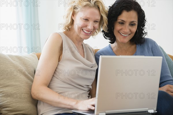 Female friends using laptop. Photo : Jamie Grill