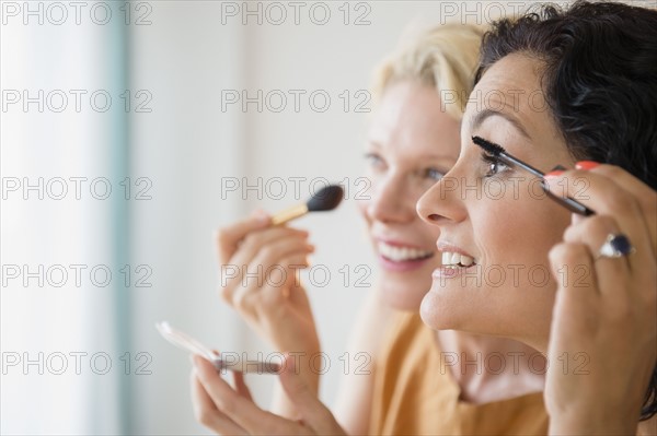 Female friends during applying make-up. Photo : Jamie Grill
