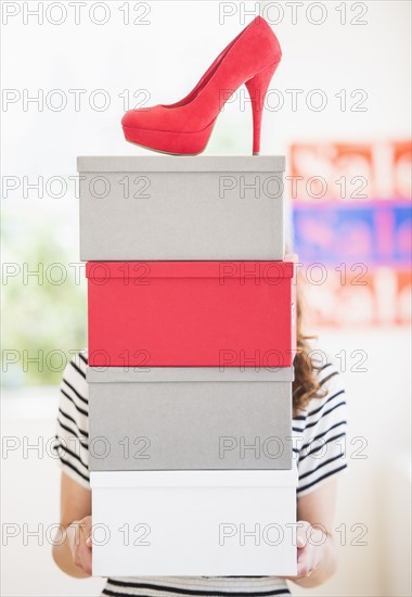 Woman carrying shoes boxes. Photo : Daniel Grill