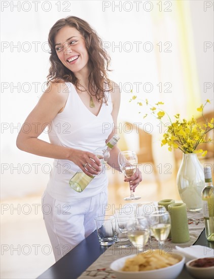 Woman pouring wine to glass. Photo : Daniel Grill