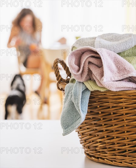 Woman in kitchen with laundry basket in foreground. Photo : Daniel Grill
