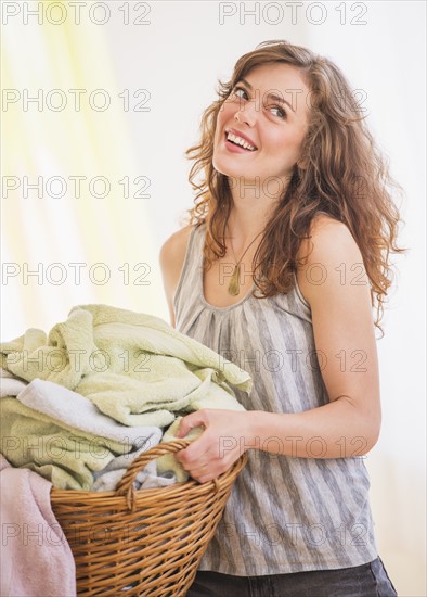 Woman carrying laundry basket. Photo : Daniel Grill