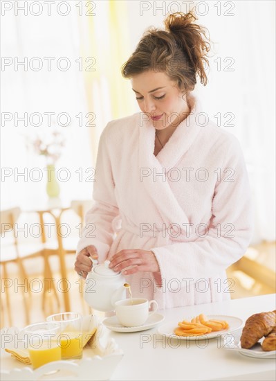 Young woman preparing breakfast. Photo : Daniel Grill