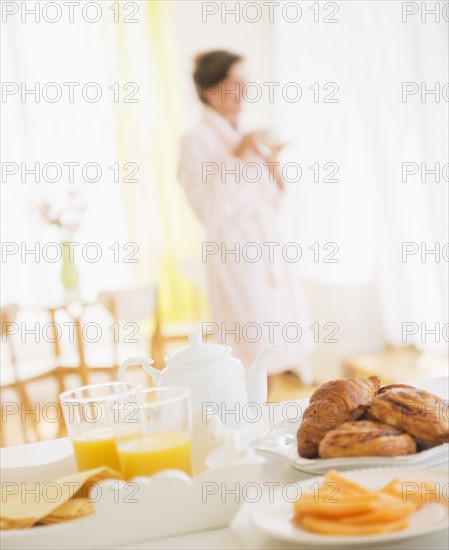 Woman in white robe drinking tea. Photo : Daniel Grill