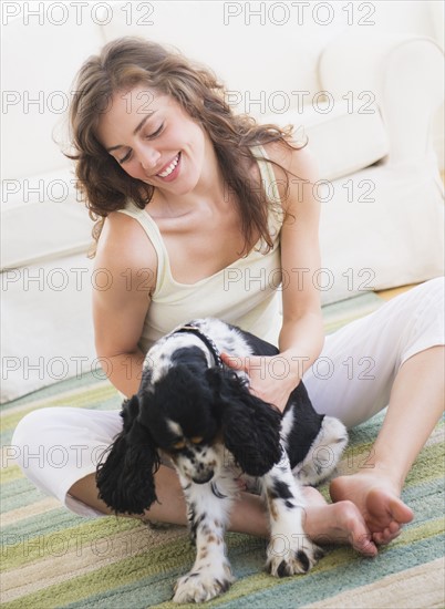Portrait of young woman playing with dog. Photo : Daniel Grill