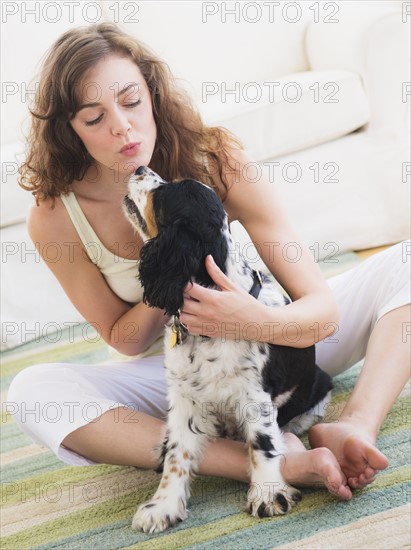 Portrait of young woman playing with dog. Photo : Daniel Grill