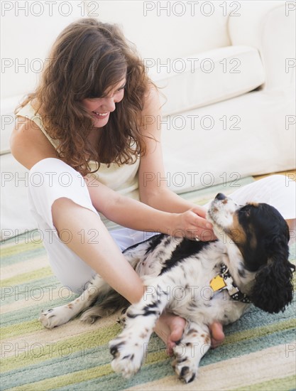 Portrait of young woman playing with dog. Photo : Daniel Grill