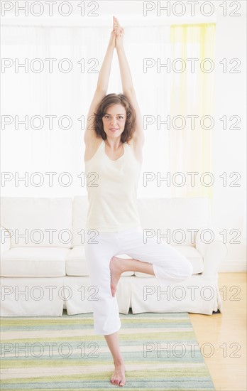 Young woman exercising at home. Photo : Daniel Grill