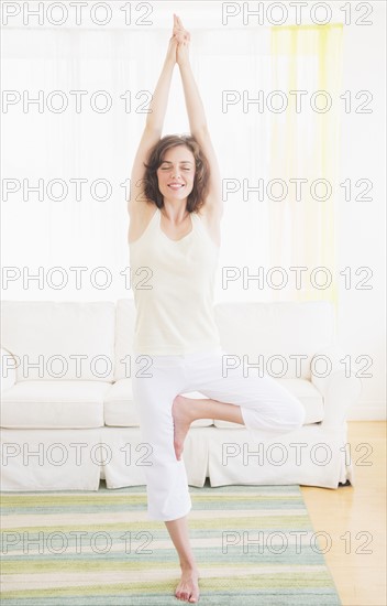 Young woman exercising at home. Photo : Daniel Grill