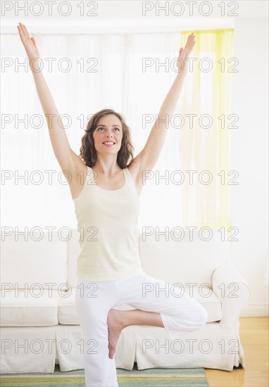 Young woman exercising at home. Photo : Daniel Grill
