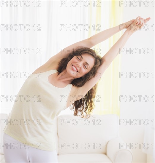 Young woman exercising at home. Photo : Daniel Grill