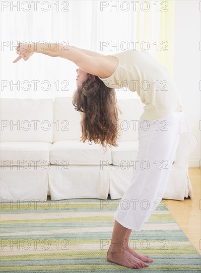 Young woman exercising at home. Photo : Daniel Grill