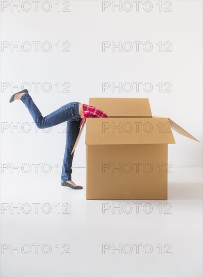 Studio shot of young woman looking into box. Photo : Daniel Grill