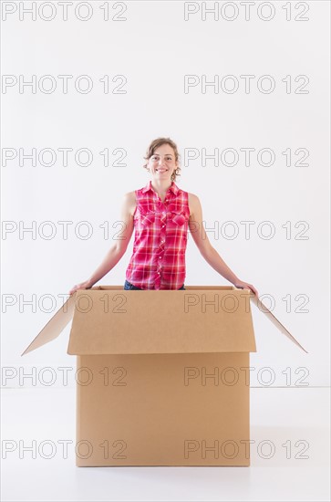Studio shot of young woman inside box. Photo: Daniel Grill