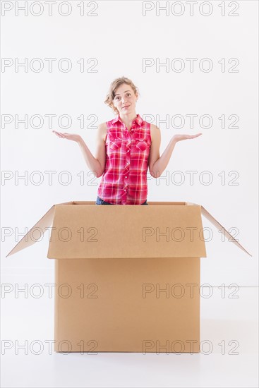 Studio shot of young woman inside box. Photo : Daniel Grill
