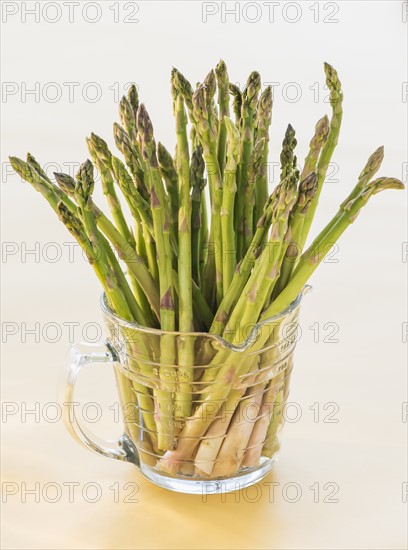 Bunch of asparagus in glass, studio shot. Photo: Daniel Grill