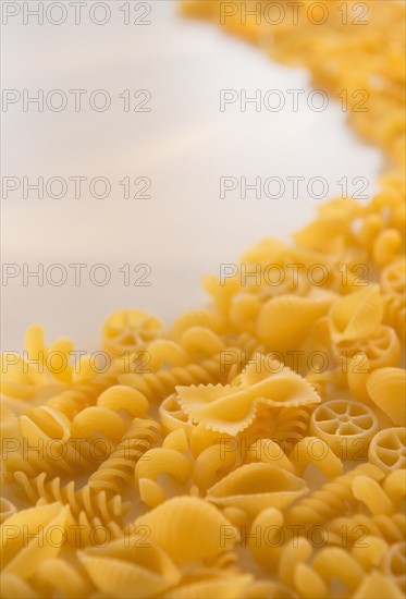 Variety of yellow pasta with blank white space in upper left corner. Photo : Daniel Grill