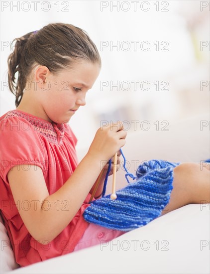 Young girl (8-9) knitting . Photo : Daniel Grill