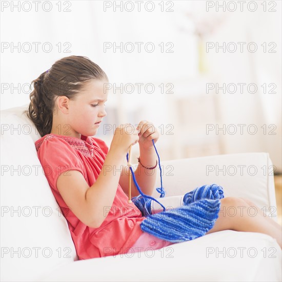 Young girl (8-9) knitting . Photo: Daniel Grill