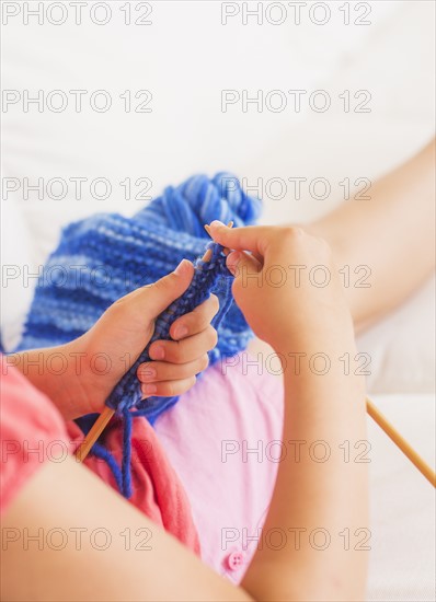 Young girl (8-9) knitting . Photo : Daniel Grill