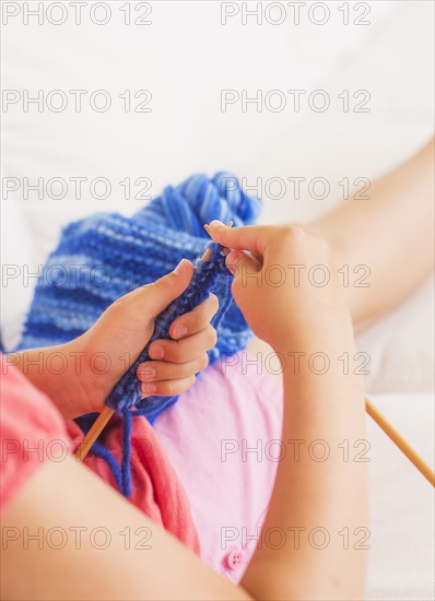 Young girl (8-9) knitting . Photo: Daniel Grill