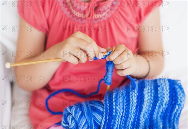 Young girl (8-9) knitting . Photo : Daniel Grill