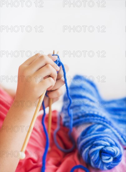 Young girl (8-9) knitting . Photo : Daniel Grill