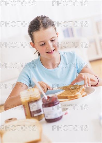 Happy young girl (8-9) having breakfast. Photo : Daniel Grill