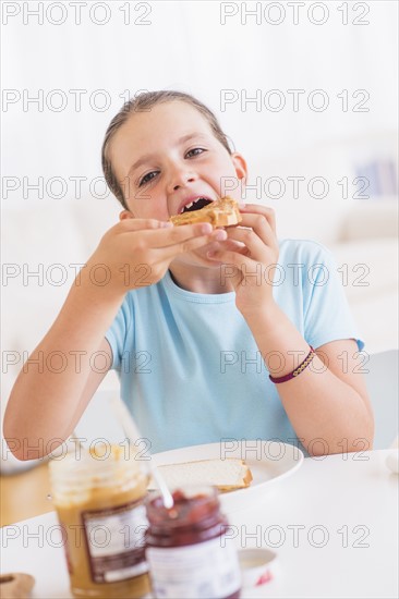 Happy young girl (8-9) having breakfast. Photo : Daniel Grill