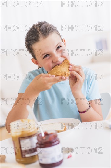 Happy young girl (8-9) having breakfast. Photo: Daniel Grill