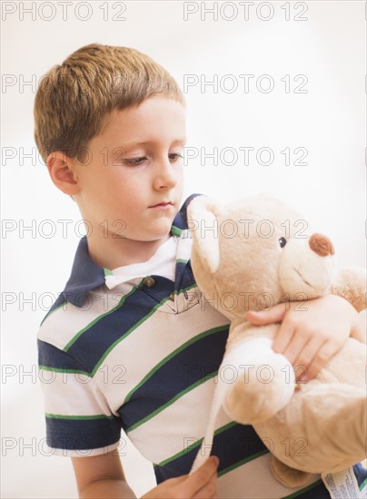 Boy (6-7) hugging his teddy-bear. Photo : Daniel Grill