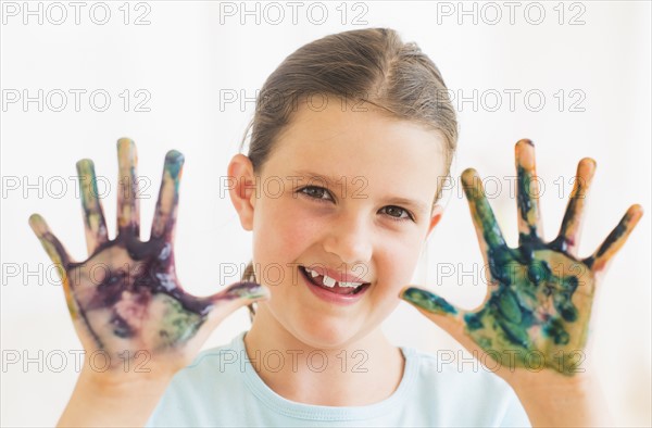 Young girl (8-9) showing hands stained with paint. Photo : Daniel Grill