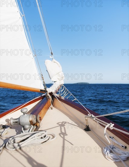 View of sea with yacht bow and sail in foreground. Photo : Daniel Grill