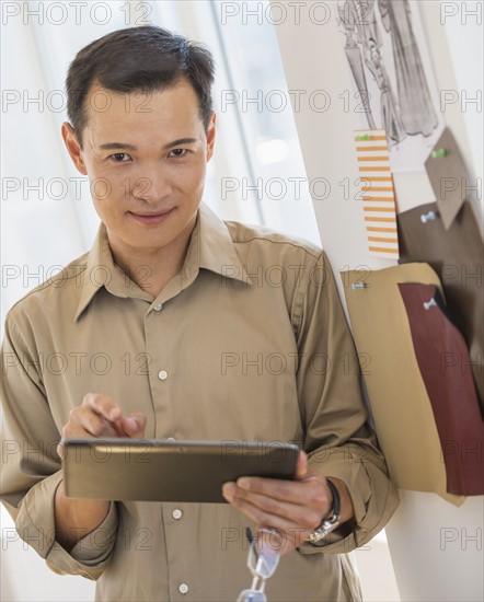 Mid adult fashion designer using digital tablet. Photo : Daniel Grill