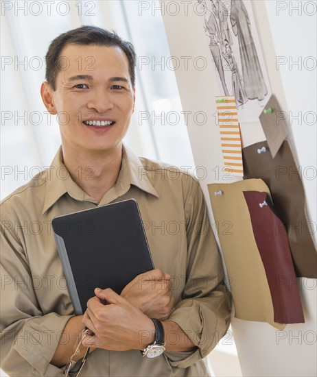 Mid adult fashion designer using digital tablet. Photo: Daniel Grill