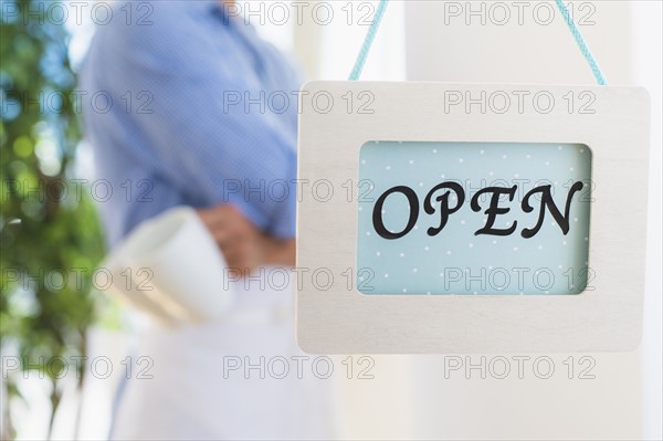 Waiter standing next to open sign. Photo: Daniel Grill