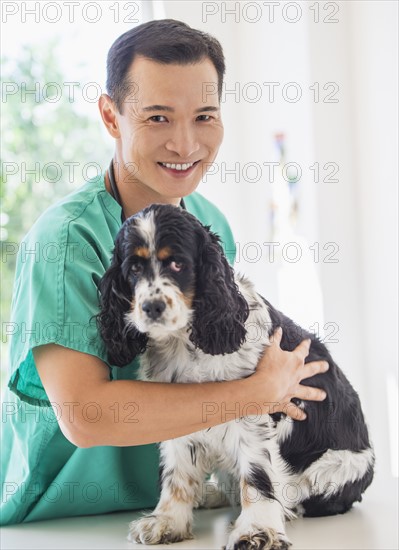 Mid adult vet attending to dog. Photo : Daniel Grill