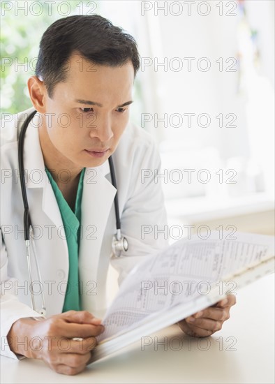 Doctor examining medical records. Photo : Daniel Grill