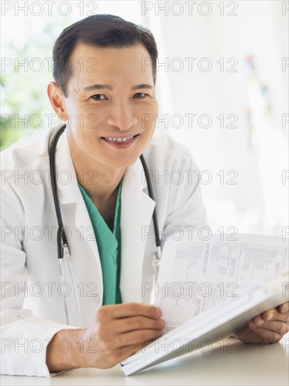 Doctor examining medical records. Photo : Daniel Grill